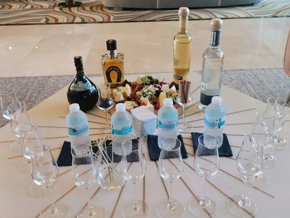 Mesa de degustación con copas, botellas y pequeños utensilios para preparar bebidas.